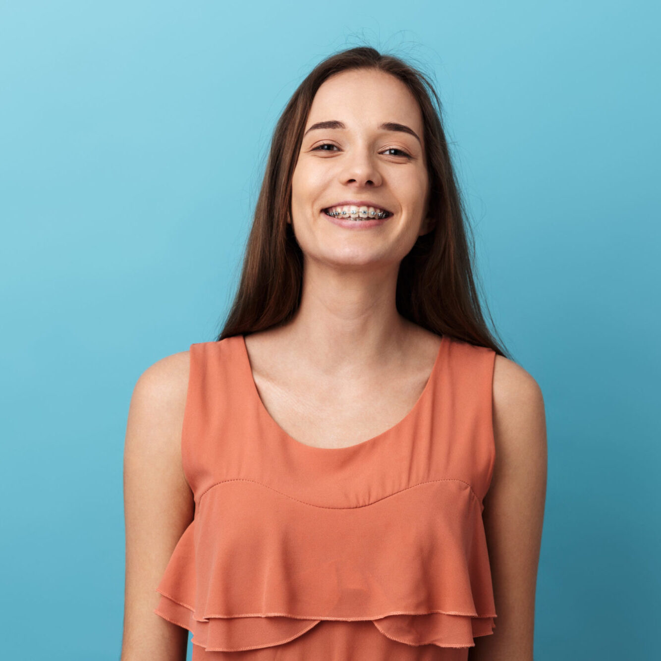 Cute lovely young girl standing isolated over blue background, posing